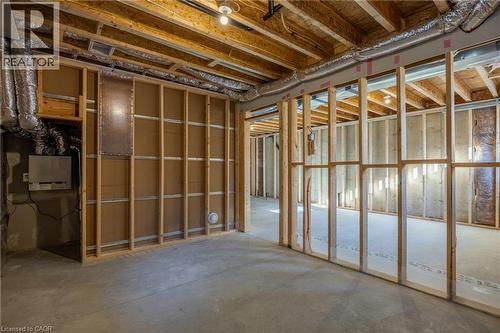 Unfinished basement featuring exposed wood joists, concrete flooring, stud framing, visible ductwork, and electrical conduit - 107 Amber Street, Waterford, ON - Indoor Photo Showing Basement