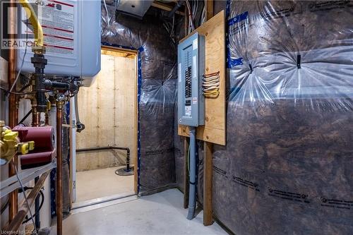 Utility area featuring a wall-mounted water heater, copper piping, and an electrical service panel - 107 Amber Street, Waterford, ON - Indoor