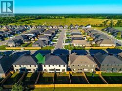 New construction neighborhood featuring multiple two-story homes with dark shingle roofs - 