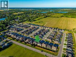 Aerial perspective of a developed residential neighborhood featuring rows of single-family homes with dark-toned roofing - 