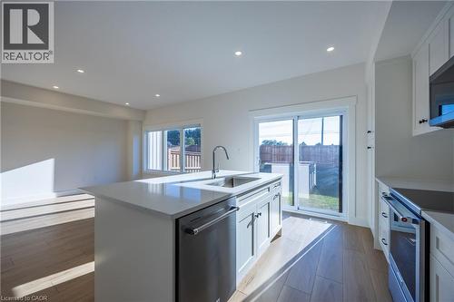 Contemporary kitchen island featuring a stainless steel undermount sink, gooseneck faucet, and integrated dishwasher - 107 Amber Street, Waterford, ON - Indoor Photo Showing Kitchen