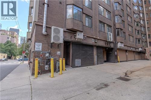 Brick exterior featuring multiple bay windows and ground-level utility access - 96 Gerrard St E, Toronto, ON 