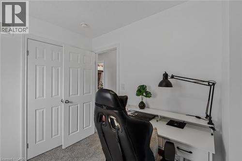 Bright interior space featuring white walls, textured carpeting, and white panel doors with brushed nickel hardware - 174 Woodway Trail, Simcoe, ON - Indoor