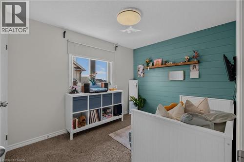 Room featuring a shiplap accent wall, neutral carpeting, and a window with a roller shade - 174 Woodway Trail, Simcoe, ON - Indoor