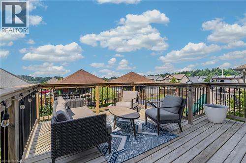 Spacious wooden deck featuring a perimeter railing with black spindles and string lighting - 174 Woodway Trail, Simcoe, ON - Outdoor With Deck Patio Veranda