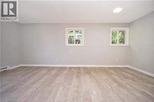 Spacious room featuring wood-finish flooring, light gray wall paint, and white baseboards - 119 Cedar Street S Unit# 14, Kitchener, ON - Indoor Photo Showing Other Room