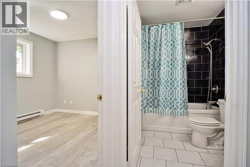 Bathroom featuring a white bathtub, dark subway tile surround, and white floor tiling - 119 Cedar Street S Unit# 14, Kitchener, ON - Indoor Photo Showing Bathroom
