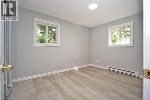 Room featuring light gray walls, wood-finish flooring, and white baseboards - 119 Cedar Street S Unit# 14, Kitchener, ON - Indoor Photo Showing Other Room