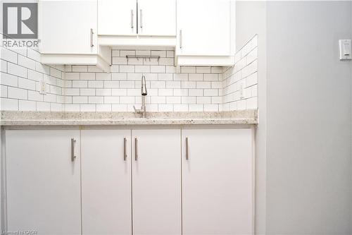 White cabinetry with brushed nickel hardware, light-toned countertop, and classic subway tile backsplash - 119 Cedar Street S Unit# 14, Kitchener, ON - Indoor Photo Showing Kitchen