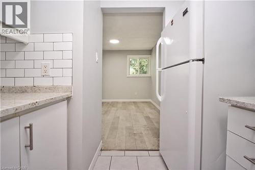 Kitchen area featuring white cabinetry, subway tile backsplash, and light-toned countertop - 119 Cedar Street S Unit# 14, Kitchener, ON - Indoor