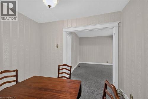 Room featuring light-toned striped wallpaper, an overhead flush-mount light fixture, and a cased opening with white trim - 155 Newlands Avenue, Hamilton, ON - Indoor