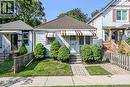 Charming bungalow exterior featuring horizontal siding, a red and white striped awning, and a tiled roof - 155 Newlands Avenue, Hamilton, ON  - Outdoor 