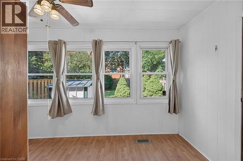 Room featuring three windows with exterior views, wood-finish flooring, and a ceiling fan with integrated lighting - 155 Newlands Avenue, Hamilton, ON - Indoor Photo Showing Other Room