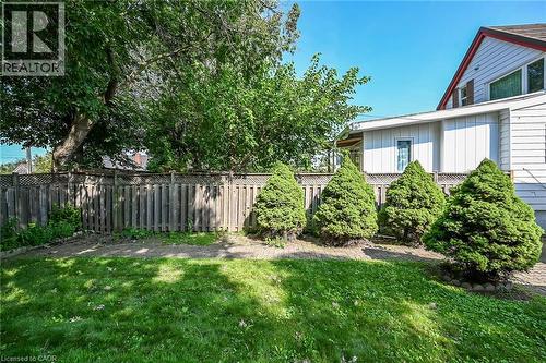Expansive backyard featuring a lush lawn, mature trees, and a wooden privacy fence with lattice detailing - 155 Newlands Avenue, Hamilton, ON - Outdoor
