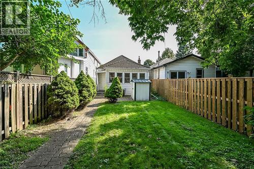 Expansive backyard featuring a manicured lawn, paved pathway, and privacy fencing - 155 Newlands Avenue, Hamilton, ON - Outdoor