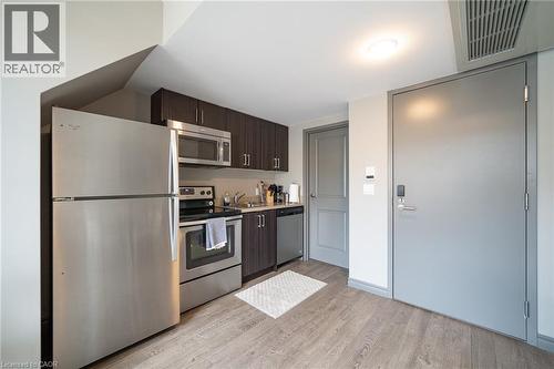 Compact kitchen featuring stainless steel appliances, including a refrigerator, range, microwave, and dishwasher - 321 Spruce Street Unit# 710, Waterloo, ON - Indoor Photo Showing Kitchen With Stainless Steel Kitchen