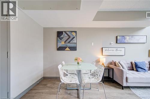 Dining area featuring wood-finish flooring, a glass-top table, and modern chairs - 321 Spruce Street Unit# 710, Waterloo, ON - Indoor Photo Showing Dining Room