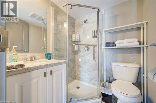 Bathroom featuring a walk-in shower with glass enclosure, white vanity with stone-finish countertop, and a built-in mirror - 321 Spruce Street Unit# 710, Waterloo, ON - Indoor Photo Showing Bathroom