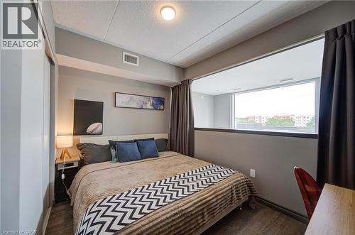 Well-lit sleeping area featuring a built-in window opening, wood-finish flooring, and a flush-mount ceiling light - 321 Spruce Street Unit# 710, Waterloo, ON - Indoor Photo Showing Bedroom