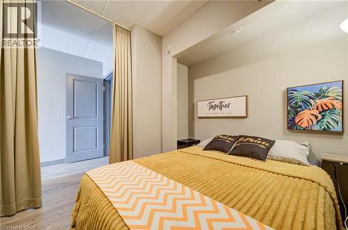 Room featuring wood-finish flooring, recessed lighting, a neutral paint palette, and a light-colored interior door - 321 Spruce Street Unit# 710, Waterloo, ON - Indoor Photo Showing Bedroom