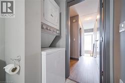 Stacked laundry unit with white appliances, set within a neutral-toned interior - 