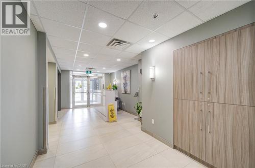 Modern entryway featuring double glass doors, recessed lighting, grid acoustic ceiling, and wood-finish cabinetry - 321 Spruce Street Unit# 710, Waterloo, ON - Indoor Photo Showing Other Room