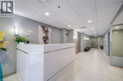 Bright reception area featuring a white, contemporary desk, recessed lighting, and light-toned floor tiling - 321 Spruce Street Unit# 710, Waterloo, ON - Indoor Photo Showing Other Room