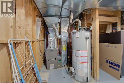 Utility room featuring a water heater, furnace, and exposed wood framing - 729 Keats Way, Waterloo, ON - Indoor Photo Showing Basement