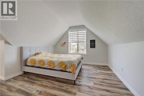 Room featuring wood-finish flooring, a window with horizontal blinds, and a sloped ceiling - 729 Keats Way, Waterloo, ON - Indoor Photo Showing Bedroom
