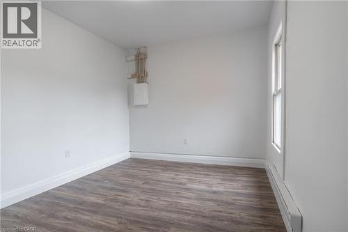 Versatile room featuring wood-finish flooring, crisp white walls, and a large window providing natural illumination - 524 King Street E Unit# 3, Hamilton, ON - Indoor Photo Showing Other Room