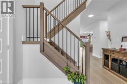 Staircase featuring wood-finish treads and handrails with black metal balusters - 