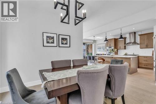 Dining area with a striking black geometric chandelier, featuring light wood-finish flooring - 2195 Ironwood Road, London, ON - Indoor Photo Showing Dining Room