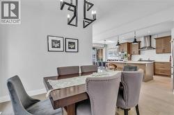 Dining area with a striking black geometric chandelier, featuring light wood-finish flooring - 