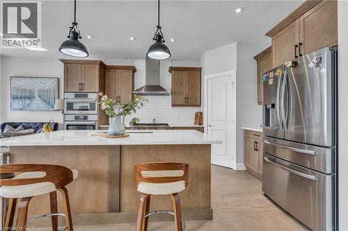 Kitchen featuring light wood-finish cabinetry, stainless steel appliances, a white subway tile backsplash, and a large island with a light-toned countertop - 2195 Ironwood Road, London, ON - Indoor Photo Showing Kitchen With Stainless Steel Kitchen With Upgraded Kitchen