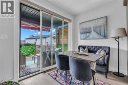 Sliding glass patio door opening to an outdoor living space with a wood deck and artificial foliage privacy screen - 