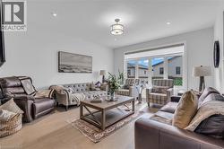 Bright living area featuring wood-finish flooring, recessed lighting, and a large multi-pane window - 