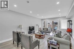 Spacious living area featuring light wood-finish flooring, recessed lighting, and light-toned walls - 