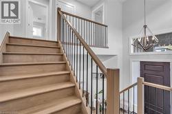 Light wood-finish staircase with black metal balusters and a wood handrail - 
