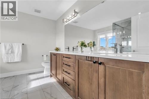 Bathroom featuring a dual vanity with wood cabinetry, white countertops, and chrome fixtures - 2195 Ironwood Road, London, ON - Indoor Photo Showing Bathroom