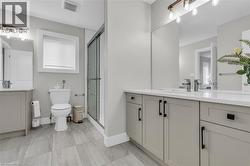 Contemporary bathroom featuring a double vanity with light gray cabinetry, white countertops, and chrome fixtures - 