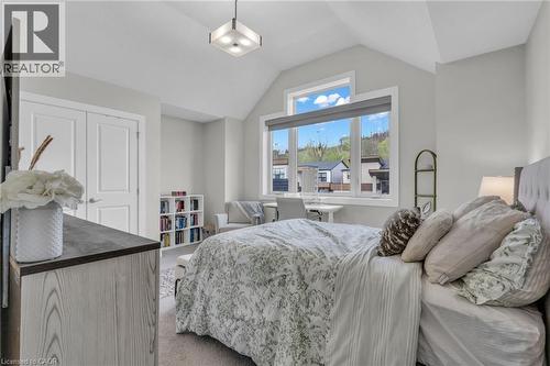 Vaulted ceiling bedroom featuring large windows, a built-in closet with double doors, and recessed shelving - 2195 Ironwood Road, London, ON - Indoor Photo Showing Bedroom