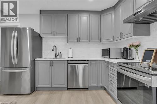 Kitchen featuring light gray cabinetry, stainless steel appliances, white countertops, and a white subway tile backsplash - 2195 Ironwood Road, London, ON - Indoor Photo Showing Kitchen With Stainless Steel Kitchen