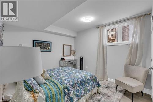 Bedroom featuring a window with natural light, light gray wall paint, a built-in ceiling light fixture, wood-finish flooring, and white baseboards - 2195 Ironwood Road, London, ON - Indoor Photo Showing Bedroom