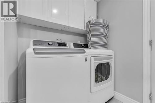 Dedicated laundry area featuring overhead cabinetry for storage and light gray wall paint - 2195 Ironwood Road, London, ON - Indoor Photo Showing Laundry Room