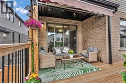 Covered outdoor patio with a wood-finish deck, brick exterior, and sliding glass door access - 