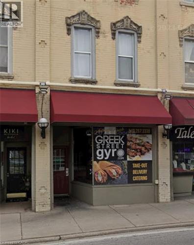 Commercial storefront with brick facade and red awnings, featuring prominent street-level retail space - 33 Ainslie Street, Cambridge, ON 