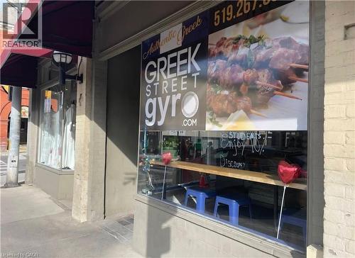 Storefront featuring large display windows and a red retractable awning - 33 Ainslie Street, Cambridge, ON 