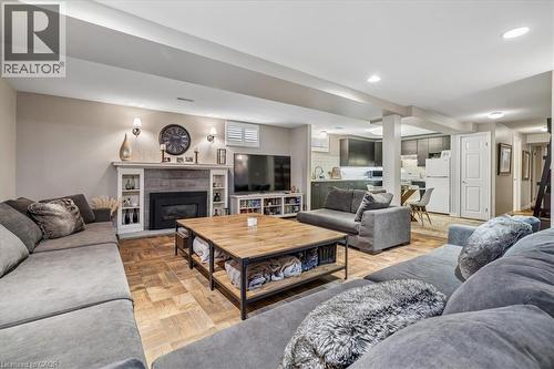 Spacious living area featuring wood-finish flooring, recessed lighting, and a fireplace with a stone surround and mantle - 573 Beach Boulevard, Hamilton, ON - Indoor Photo Showing Living Room With Fireplace