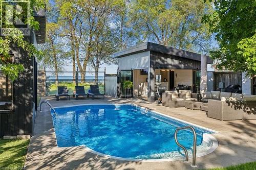Rectangular swimming pool with integrated steps, surrounded by concrete decking - 573 Beach Boulevard, Hamilton, ON - Outdoor With In Ground Pool With Deck Patio Veranda