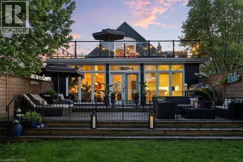 Expansive rear deck featuring multiple seating areas, a privacy fence, and direct access to the interior through large glass doors - 573 Beach Boulevard, Hamilton, ON - Outdoor With Deck Patio Veranda